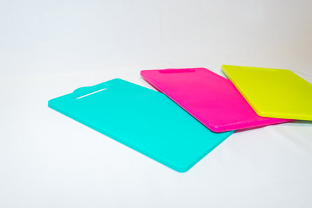 The Blue, Yellow, and Pink Plastic Cutting Board is a set of vibrant and practical kitchen essentials.の写真素材