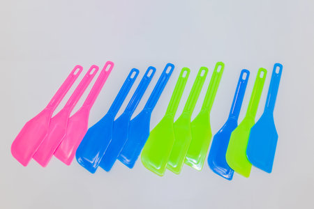 The Colorful Plastic Spatula Set includes spatulas in vibrant shades of pink, blue, and green, making it a delightful addition to your kitchen tools.の写真素材