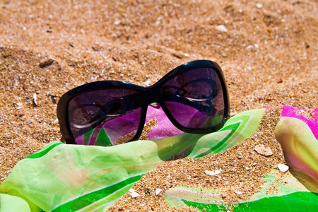 Sun glass on sand background の写真素材