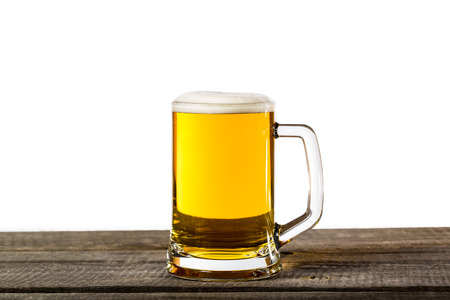 Beer glass with foam isolated on a vintage wooden tableの写真素材