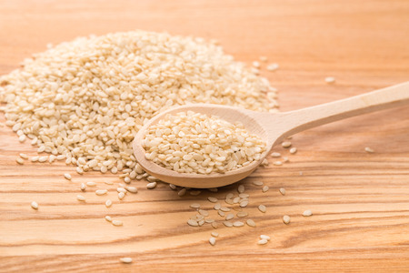Organic natural sesame seeds in the wooden spoon on wood tableの写真素材