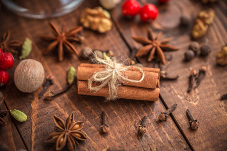Collection of spices for mulled wine and pastry on the wooden tableの写真素材