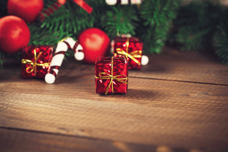 Christmas gift box with red ribbon on dark wooden background in vintage styleの写真素材
