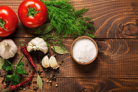 Pepper and tomatoes with garlic on a vintage wooden tableの写真素材