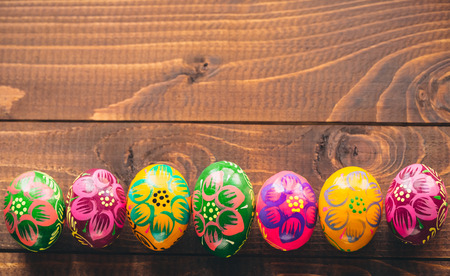 Beautiful painted colorful Easter eggs on old brown wooden backgroundの写真素材