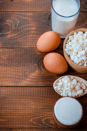 Natural homemade products: milk, cheese, sour cream and eggs on old wooden backgroundの写真素材