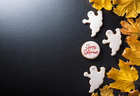 Funny delicious ginger biscuits for Halloween with yellow leaves on the dark background.の写真素材