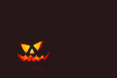 Glowing pumpkin symbolizing the head of old Jack on night spooky dark background. Soft focus. shallow DOFの写真素材