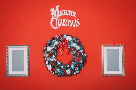 Beautiful new year wreath with branches of spruce and toys with wishes for a happy Christmasの写真素材