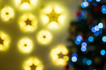 Closeup of Christmas-tree background in the living room of the house with glowing stars on the wallの写真素材