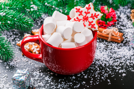 Beautiful Christmas background with Cup of marshmallows,  gingerbread and Christmas decor on black tableの写真素材