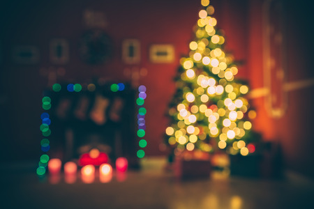 Beautiful  Defocused background new year room with decorated Christmas tree, gifts and fireplace with the glowing lights at night. The idea for postcards. Soft focus. Shallow DOFの写真素材