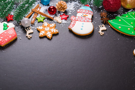 Christmas cookies with candy, cone and fir festive decoration with snow. View with copy space