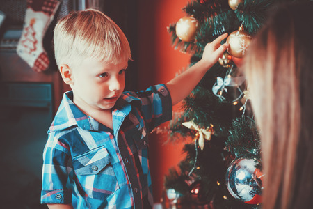 beautiful portrait of happy mother and son decorating Christmas tree in New year room. The idea for postcards. Soft focus. Shallow dofの写真素材