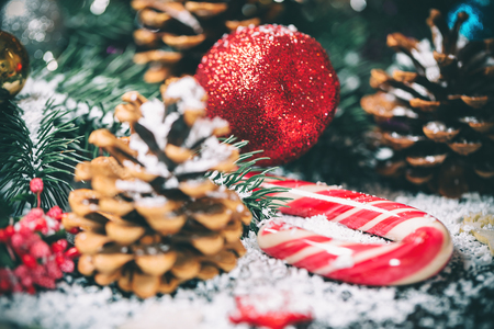 Christmas ornaments with decor, cone and candy on snow backgroundの写真素材