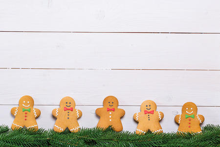 Cookies with branches Christmas tree. Gingerbreads men on white wooden background. Free space for Merry Christmas text.の写真素材