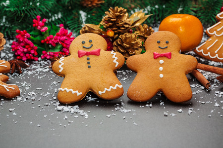 Christmas cookies with cone and fir festive with decor. Gingerbreads on black background with snow....