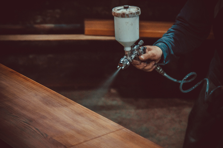 Master painter in a factory - industrial painting  wood with spray gun. Soft focus. Shallow DOF.の写真素材
