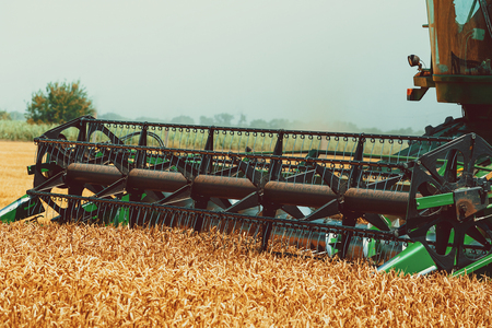 Photo of combine harvester that is harvesting crop.
