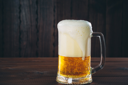 Mug of beer on the wooden background. Beautiful background of the Oktoberfestの写真素材