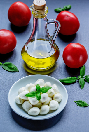 Mozzarella, red tomatoes and fresh Basil on a black background. top view. Flat lay. Food concept. Healthy and wholesome foodの写真素材