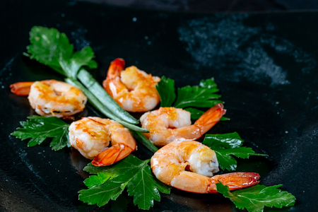 Fresh peeled grilled shrimp with herbs on black background. Flatley. Food background a gourmet mealの写真素材