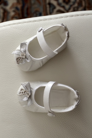 The white shoes for child's christening on white backgroundの写真素材