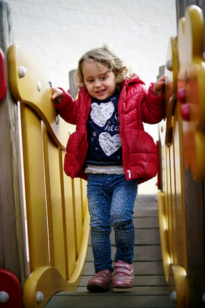 Little happy girl playing on the playgroundの写真素材