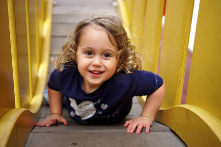 Little happy girl playing on the playgroundの写真素材