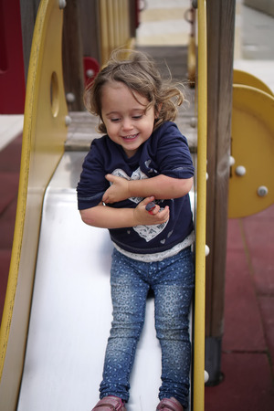 Little happy girl playing on the playgroundの写真素材
