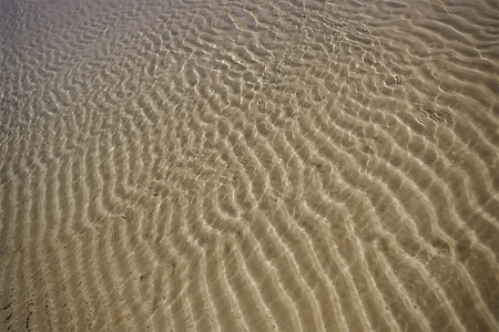 Sea sand under water in sunny day background