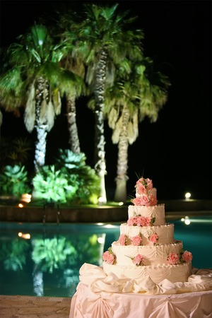wedding cake on background of pool in evening timeの写真素材