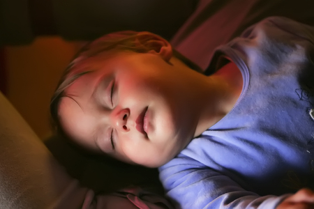 sweet sleeping baby with warm light on the faceの写真素材