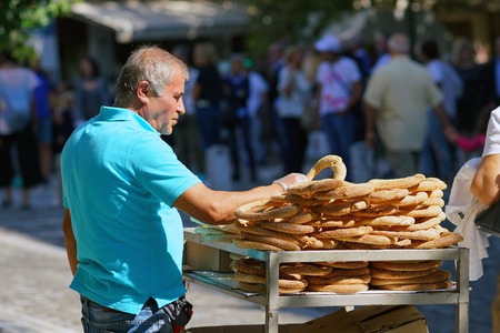 GREECE, ATHENS - OCTOBER 07, 2018 Donut seller, koulourakia, on the street in Athens, in Plaka...