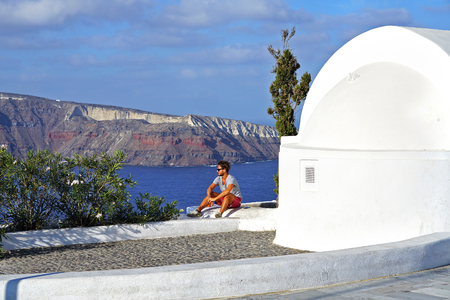 OIA - GREECE, SEPTEMBER 19 2018, A boy admires the view of the Caldera in Santoriniのeditorial素材