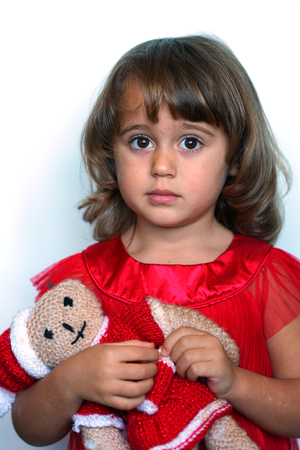 3-4 years old girl with a red dress on a white backgroundの写真素材