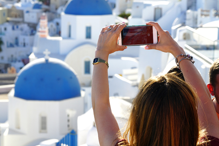 OIA, GREECE, September 19, 2018 A tourist takes a photograph using a cell phoneのeditorial素材