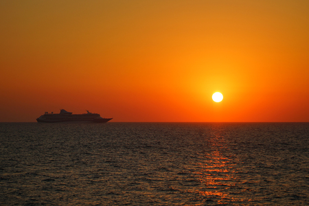 Suggestive sunset with ship in Santorini in the Cyclades Islands, Greeceの写真素材