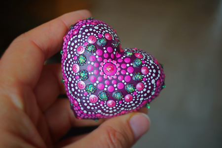 Beautiful mandala heart holding in hand