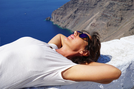 Tourist relaxing in the sun in Santorini island, Greeceの写真素材