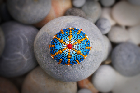 Beautiful mandala hand painted on a sea stone, with pebblesの写真素材