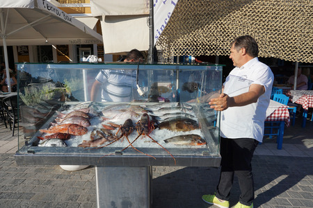 Parga, Greece, 17 July 2018 A restaurateur prepares fresh fish for customers on the Parga seafrontのeditorial素材
