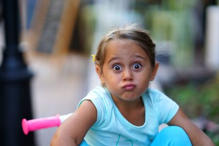 Pretty little girl with big eyes make faces, with copy spaceの写真素材