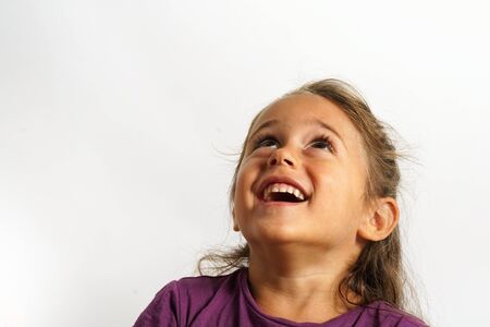portrait on white background of a 4 year old Italian girl looking up smiling
