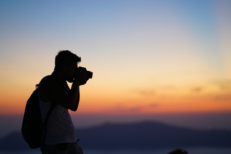 Santorini, Greece, September 21 2018, A tourist relax taking photographs of the sunset in Imerovigliのeditorial素材