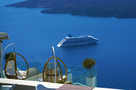 Beautiful armchairs in bamboo cane to relax with the Caldera view in Santorini, Greeceのeditorial素材