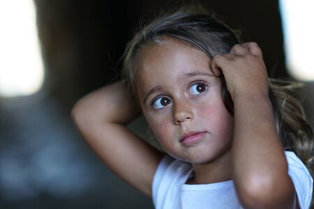 portrait of a beautiful 4 year old girl who loks sideways