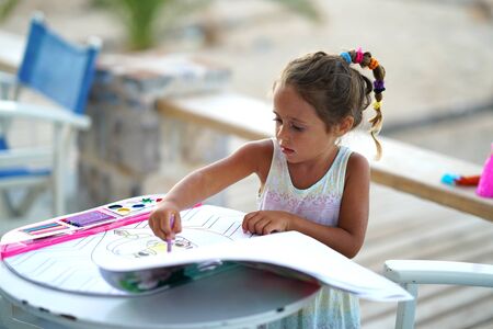 Adorable 4-year-old girl colors with interestの写真素材