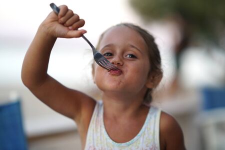 portrait of a 4 year old girl looking straight into the camera and making funny faces