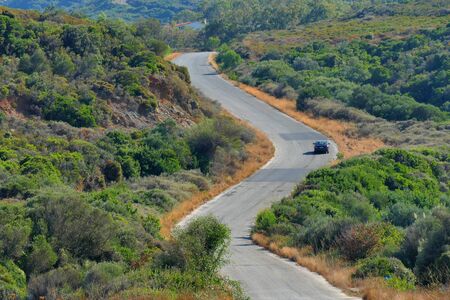 A car drives a road through the hills in the south east of the Peloponneseの写真素材
